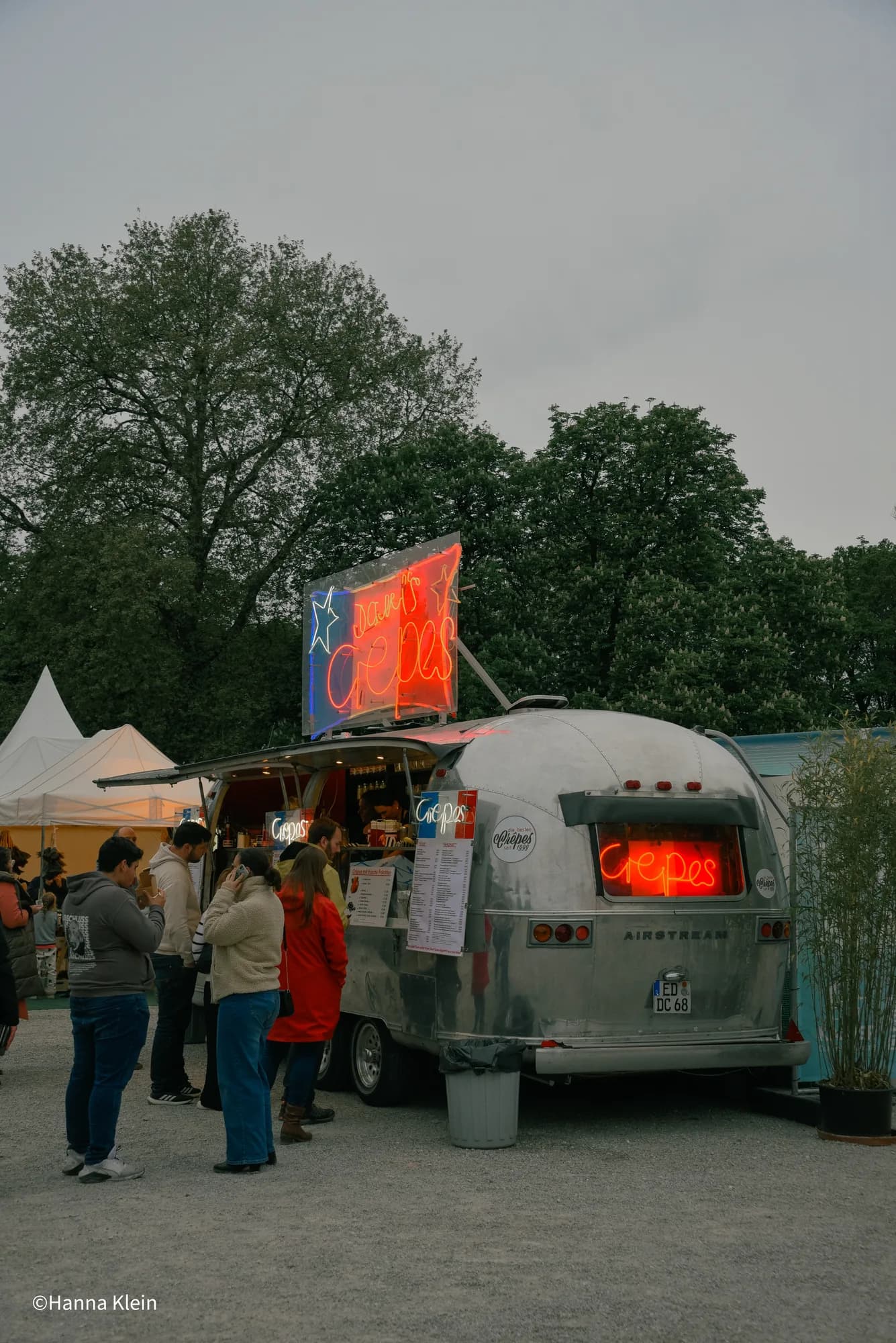 A silver Airstream food trailer parked at the festival market area.