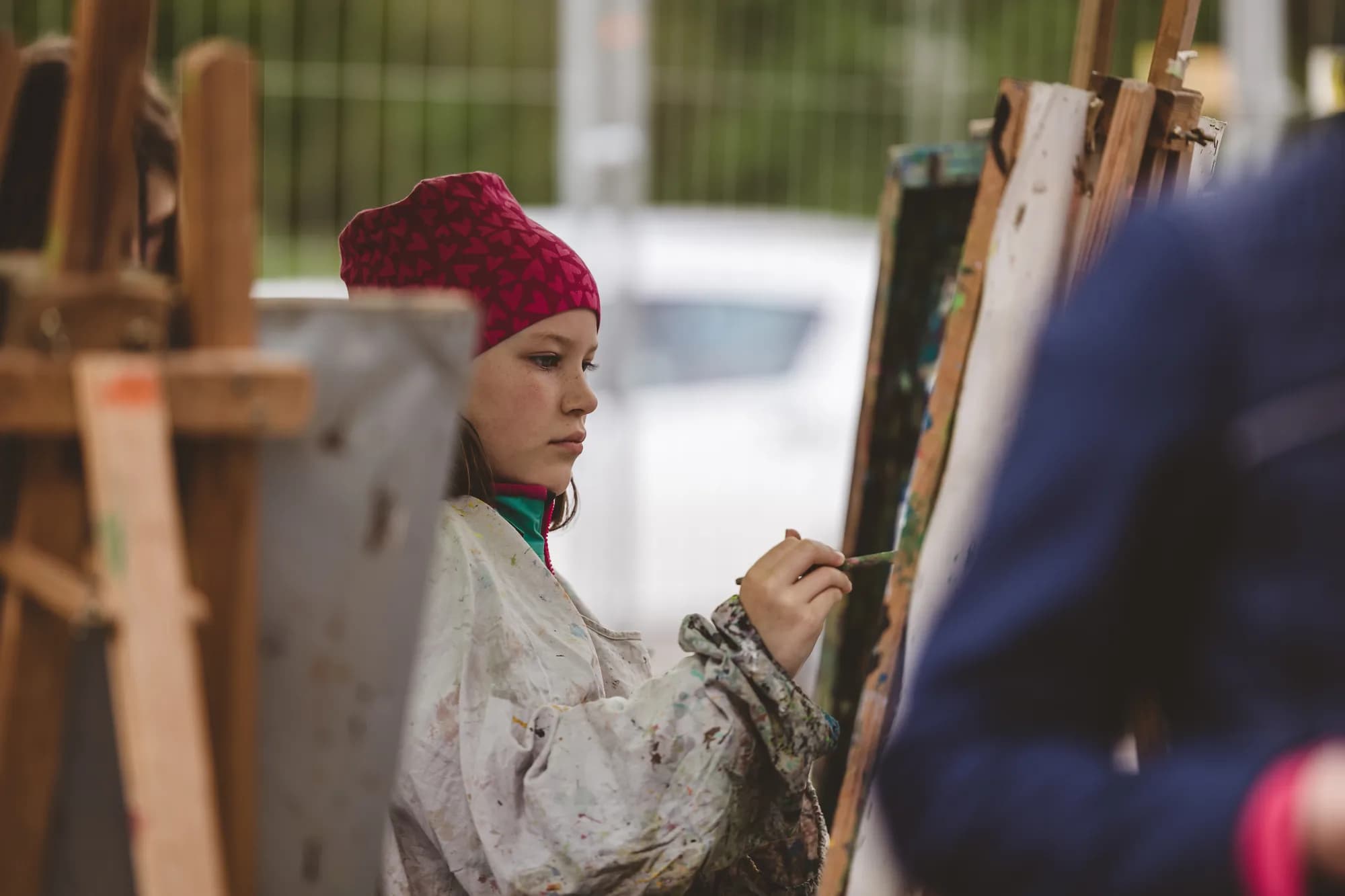 A young girl paints on an easel during a children's workshop in the Kinderland.