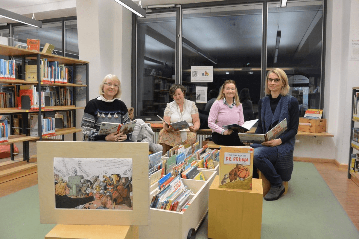 Mitarbeiter*innen der Stadtbibliothek Freising lesen Kindern auf dem Uferlos Festival vor