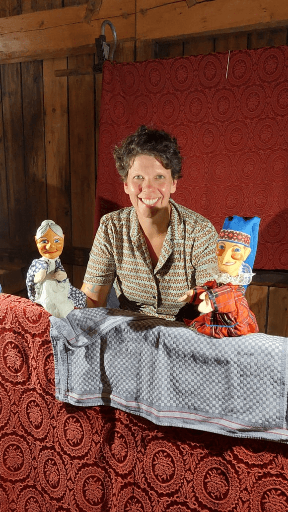 Maria Bernlochner bei einer Puppenshow mit Kasperl-Figuren