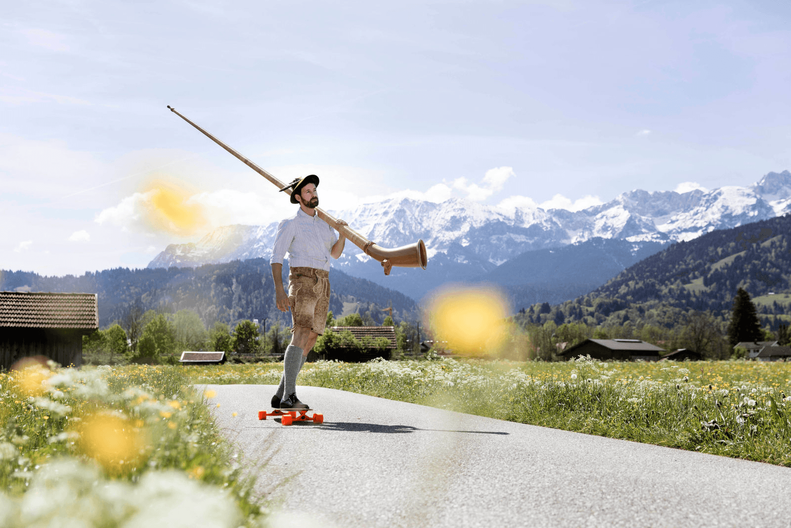 Marcel Engler playing alphorn against a mountain backdrop